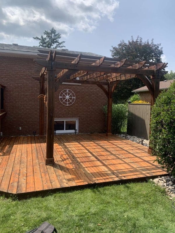 Stained deck with cedar pergola behind a brick home in Kitchener-Waterloo